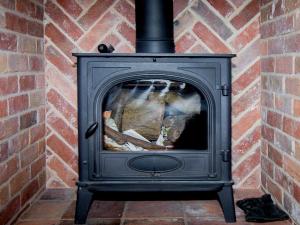 SculthorpeにあるKingfisher Barnの煉瓦壁の黒薪ストーブ