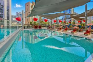 une grande piscine avec chaises et parasols sur un bâtiment dans l'établissement Downtown Dubai, Canal view ,Mag318, à Dubaï
