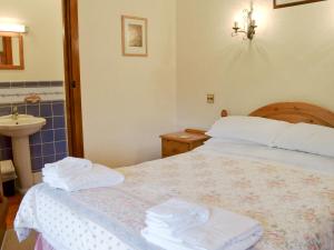 een slaapkamer met een bed met handdoeken erop bij The Granary in Colyford +7 foto's