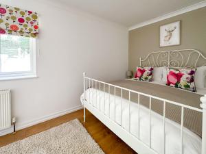 Una cuna blanca en un dormitorio con ventana. en Weavers Lodge, en Ibsley 9 fotos más