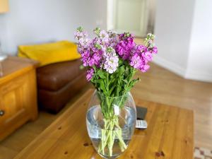 un jarrón de flores púrpuras sentado en una mesa en Weavers Lodge, en Ibsley