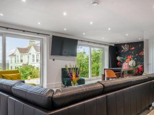 a living room with a large brown leather couch at The Aviary-Uk44382 in Callington