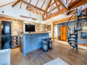 a kitchen with a blue island with a tv on it at Bockety Barn in Stalham