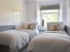 two beds sitting next to each other in a bedroom at Grange End Coach House in Grasmere +7 photos