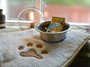 a dog sitting in a bowl on a towel at Grange End Coach House in Grasmere