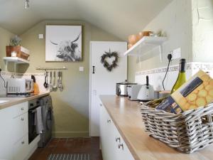 a kitchen with white cabinets and a counter at Grange End Coach House in Grasmere