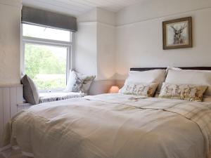a bedroom with a large bed and a window at Grange End Coach House in Grasmere
