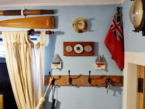 eine Wand mit Uhren und einer Flagge auf einem Schiff in der Unterkunft Boatmans Cottage - 27787 in Portessie + 17 Fotos