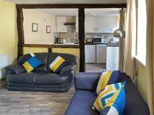 un salon avec un canapé et une cuisine dans l'établissement Orchard Bank Cottage, à Longhope