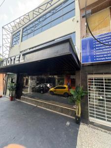 a hotel with a yellow car parked in front of it at Hotel Amazon In in Belém