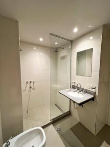 a bathroom with a glass shower and a sink at Otero Coliving - Studio Entero U4 in San Salvador de Jujuy