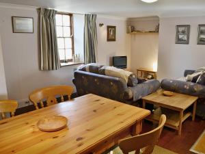 ein Wohnzimmer mit Tisch und Couch in der Unterkunft Haven Cottage - E4342 in Holy Island