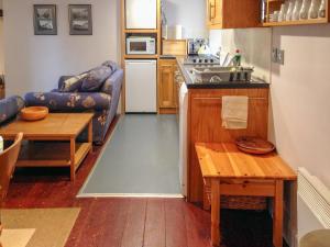 eine kleine Küche mit einem Sofa und einem Tisch in der Unterkunft Haven Cottage - E4342 in Holy Island