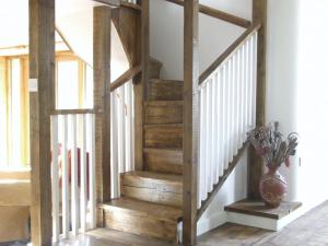 een houten trap in een woonkamer met een vaas bij Brook Lodge in Bridford +13 foto's