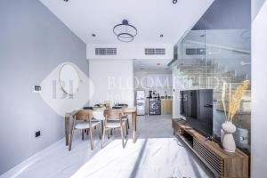 a dining room with a table and a tv at Bloomfields Deluxe 1br Rukan in Nadd Shubayḩ