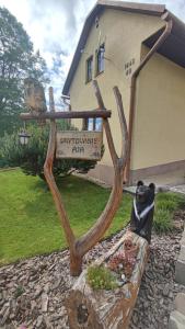 a statue of a bear sitting on a bench in front of a house at Chalupa Aja in Čierny Blh