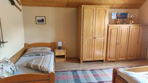 a bedroom with two beds and a wooden cabinet at Chalupa Aja in Čierny Blh
