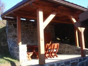 a wooden pavilion with chairs and a table at Chalupa Aja in Čierny Blh +6 photos