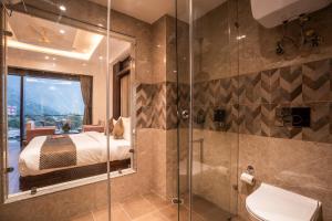 a bathroom with a bed and a glass shower at Alt Life Luxe - Uppper Bhagsu Mcleodganj in McLeod Ganj +37 photos