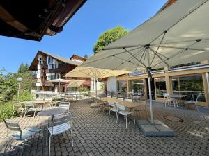 哈斯利伯格Reka-Feriendorf Hasliberg的带桌椅和遮阳伞的露台