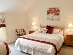 ein Schlafzimmer mit einem Bett, zwei Lampen und einem Stuhl in der Unterkunft Nan-Tis in St. Issey + 10 Fotos