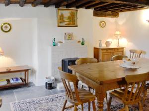 ein Esszimmer mit einem Holztisch und Stühlen in der Unterkunft Nan-Tis in St. Issey