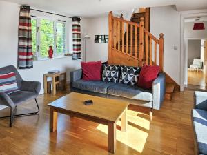 a living room with a couch and a coffee table at Stabl-Oh4 in Dihewid