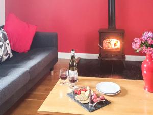 a living room with a couch and a table with wine glasses at Stabl-Oh4 in Dihewid