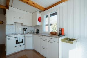 Una cocina blanca con gabinetes blancos y una ventana. en Apartment Perlita, en Amden 6 fotos más