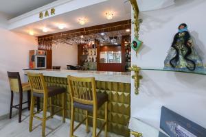 a bar with yellow chairs and a counter with a bar at Atropat Old City Hotel in Baku