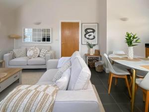 Una sala de estar con un sofá blanco y una mesa. en The Guards Quarters - Uk47594, en Silloth