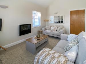 Una sala de estar con un sofá y un televisor. en The Guards Quarters - Uk47594, en Silloth