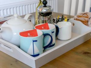 ein Tablett mit Tassen und Teekannen auf einem Tisch in der Unterkunft The Bay - The Bolthole in Reighton + 18 Fotos