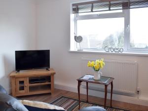 EarbyにあるCan-Y-Mor - Uk13379のリビングルーム(テレビ、黄色い花のテーブル付)