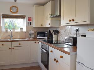 EarbyにあるCan-Y-Mor - Uk13379の白いキャビネットとシンクのあるキッチン