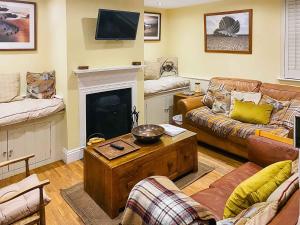ein Wohnzimmer mit Sofas und Kamin in der Unterkunft Pebble Cottage in Aldeburgh