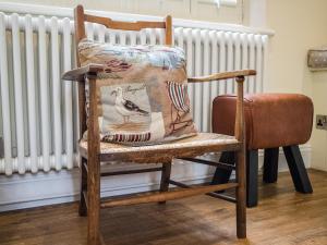 ein hölzerner Schaukelstuhl mit einem Kissen darauf in der Unterkunft Pebble Cottage in Aldeburgh + 12 Fotos