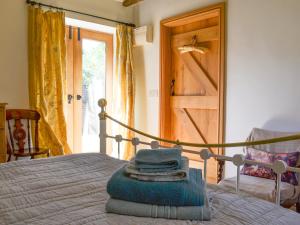 een bed met een stapel handdoeken erop bij Cornflower Cottage Ukc1897 in Dogdyke