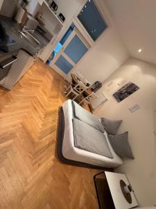 a living room with a couch and a wooden floor at Ferienwohnung Kotterer - Innenstadt Speyer in Speyer +2 photos