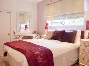 ein Schlafzimmer mit einem großen Bett und zwei Fenstern in der Unterkunft Treetops in Bowness-on-Windermere + 6 Fotos