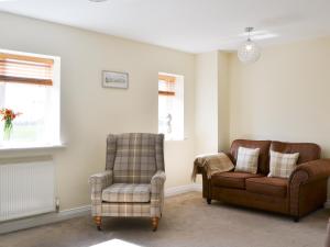 un salon avec un canapé et une chaise dans l'établissement Newcombe Cottage, à Flamborough