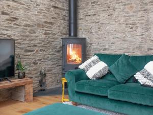 a green couch in a living room with a fireplace at Vredehoek in Quethiock +26 photos