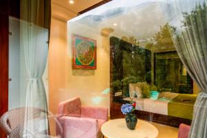 a room with a table and chairs and a vase of flowers at Alt Life Luxe - Uppper Bhagsu Mcleodganj in McLeod Ganj