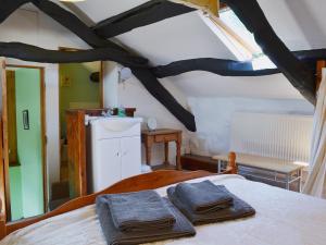 a bedroom with a bed with two towels on it at The Hayloft Barn in Criccieth