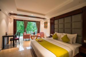 a bedroom with a large bed and a table and chairs at Alt Life Luxe - Uppper Bhagsu Mcleodganj in McLeod Ganj