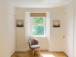 ein Stuhl in einem Raum mit einem Fenster in der Unterkunft Keepers Cottage - Uk30246 in Cray