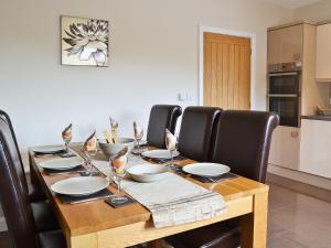 a wooden table with black chairs and a dining room at Stabl-Oh4 in Dihewid +12 photos