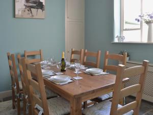 a wooden table with a bottle of wine and chairs at Waters Edge in Instow