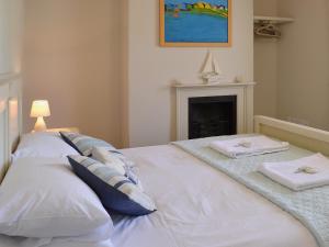 a white bed with two towels on top of it at Waters Edge in Instow +11 photos