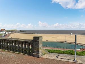 a view of the beach from a wall next to the ocean at Salty Paws in Gorleston-on-Sea